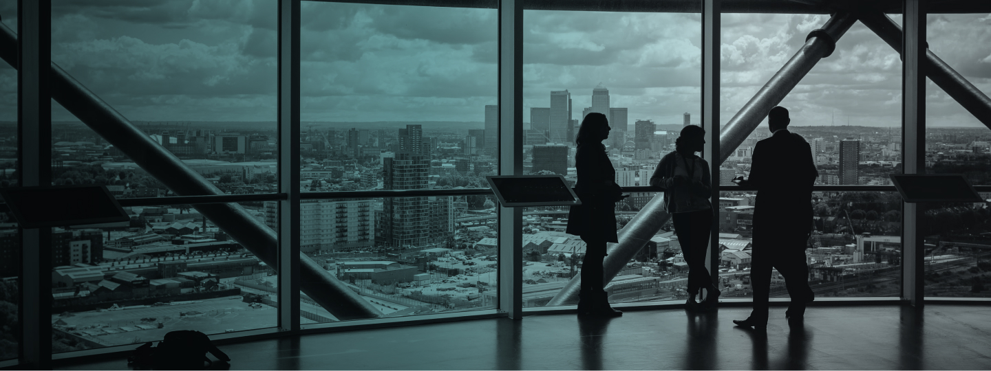 Professionals standing by office window overlooking city